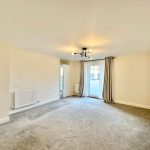 Spacious modern living room with balcony access.