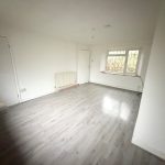 Empty room with wooden flooring.