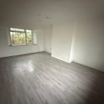 Empty room with wooden flooring and window view
