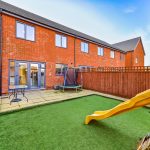 Modern UK backyard with slide and patio.