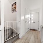Modern hallway with staircase and front door.