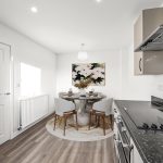 Modern kitchen dining area with round table.