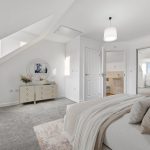Modern bedroom with ensuite bathroom and mirrored wardrobe.