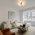 Modern lounge with beige sofa and large window.