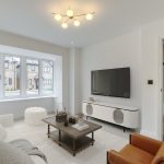 Modern living room with TV and large window.