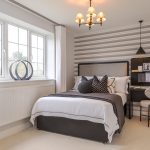 Modern bedroom with desk and striped wallpaper.
