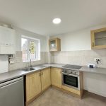 Modern kitchen with wooden cabinets and appliances.