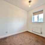 Bright empty room with window and light fixture.