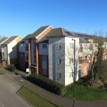 Modern apartment buildings with solar panels and road.