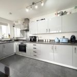 Modern kitchen with grey cabinets and appliances.