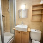 Modern bathroom with shower, sink, and toilet.