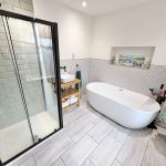 Modern bathroom with shower, bath, and sink area.