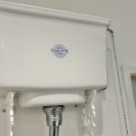 High-level cistern with visible pull chain flush.