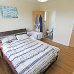 Bedroom with ensuite and wooden flooring.