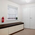 Modern hallway with bench and closet.