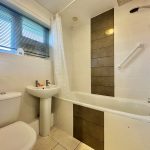 Modern bathroom with bath, shower, and sink.