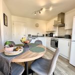 Modern kitchen with dining table and appliances.