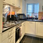 Modern kitchen with appliances and white cabinets.