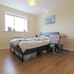 Bright bedroom with bed and bedside table.