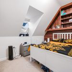 Loft bedroom with sloped ceiling and modern decor.