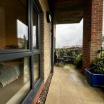 Cosy balcony with chairs overlooking a garden view.