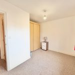 Empty bedroom with wardrobe and lamp.