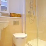 Modern bathroom with shower, toilet, and sink.