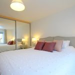 Cosy bedroom with large bed and soft lighting.