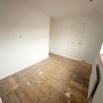 Empty room with wooden floor and white walls.