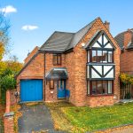 Red brick house with blue doors and garage.