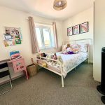 Bright children's bedroom with toys and pastel decor.