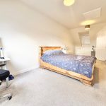 Cosy bedroom with desk, bed, and TV.