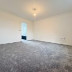 Empty room with grey carpet and white walls.