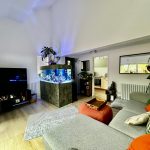 Modern living room with aquarium and plants.