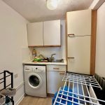 Small kitchen with appliances and drying rack.