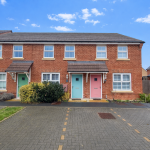 Brick houses with coloured doors and driveway.