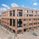 Modern four-storey brick office building on a street.