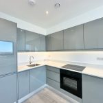 Modern kitchen with grey cabinets and oven.