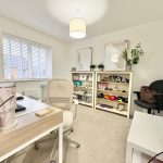 Modern home office with desk and bookshelf.