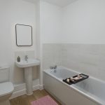 Modern bathroom with bathtub, sink, and toilet.