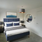 Modern bedroom with double bed and artwork.