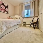 Cosy bedroom with single bed and floral decor.