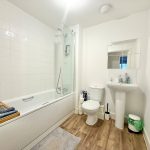 Modern bathroom with bath, sink, and toilet.