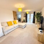 Modern living room with large sofa and TV.