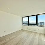 Bright empty room with large windows and city view.
