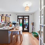 Bright kitchen with dining table and doors to garden.