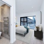 Modern bedroom with en-suite bathroom and city view.