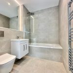 Modern bathroom with bathtub and heated towel rail.