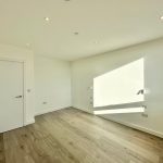Empty room with wooden floor and white walls