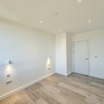 Modern empty room with wooden flooring.